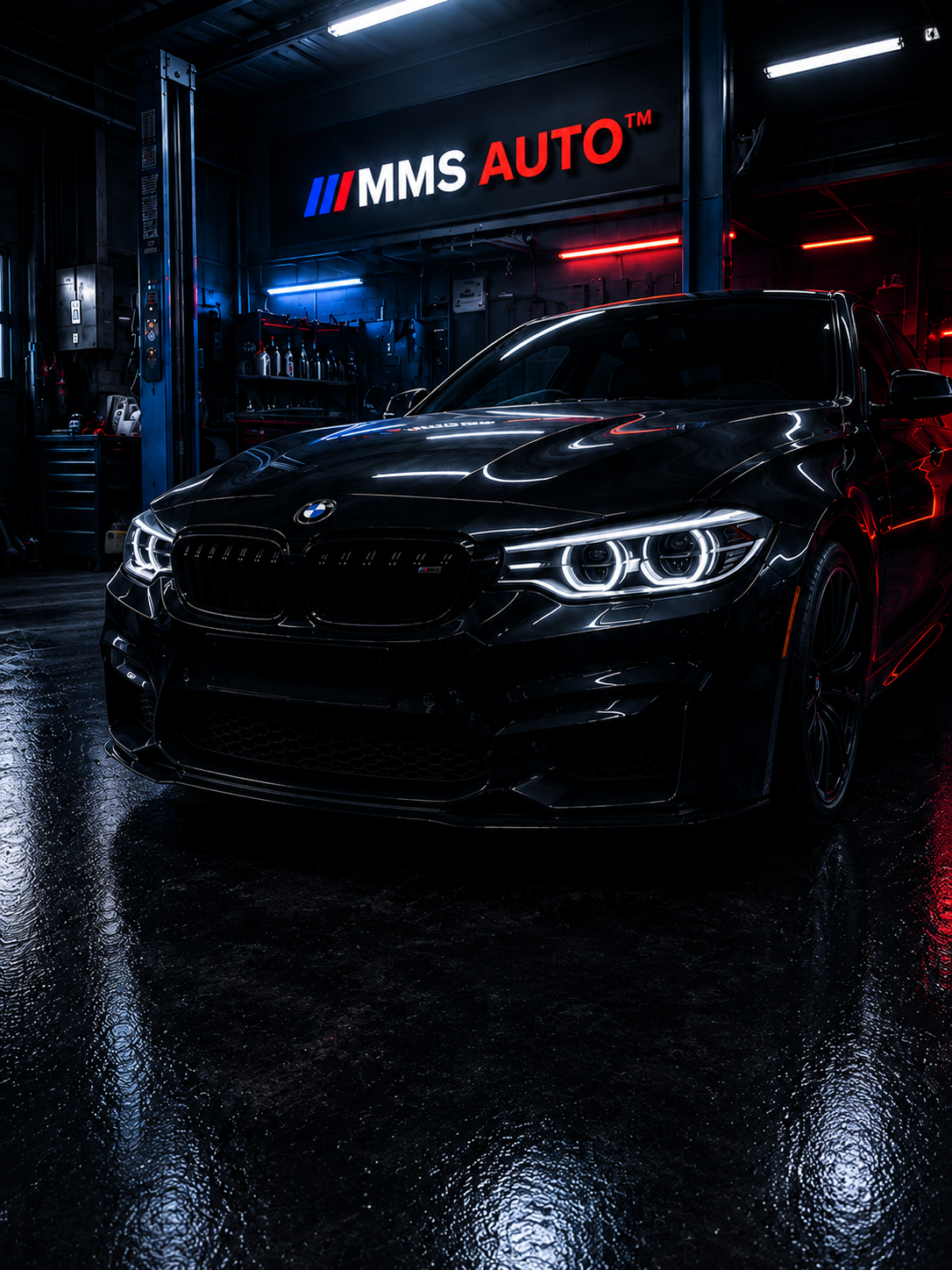 BMW M coupe under MMS Auto signage in the workshop bay